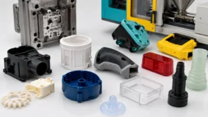 A collection of injection-molded plastic and silicone components displayed on a white workbench with a precision steel mold and an injection molding machine in the background, representing different injection molding processes used in modern manufacturing.